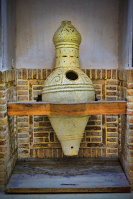 Gerald nestled in a hand-thrown ceramic pot on a wooden shelf.