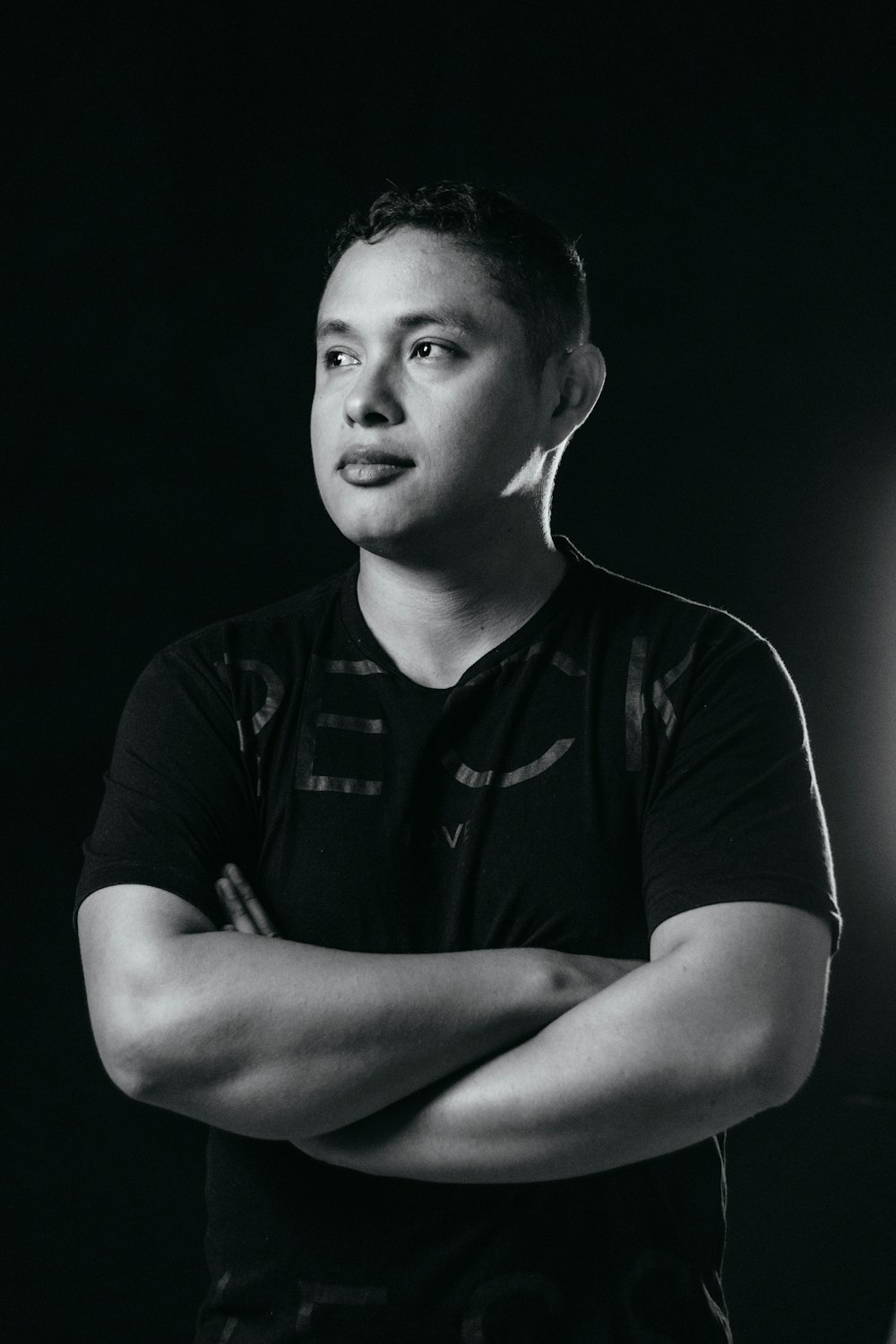 a black and white photo of a man with his arms crossed