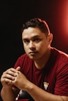 a man in a red shirt sitting at a table