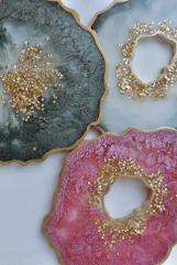 three plates with gold and pink designs on them