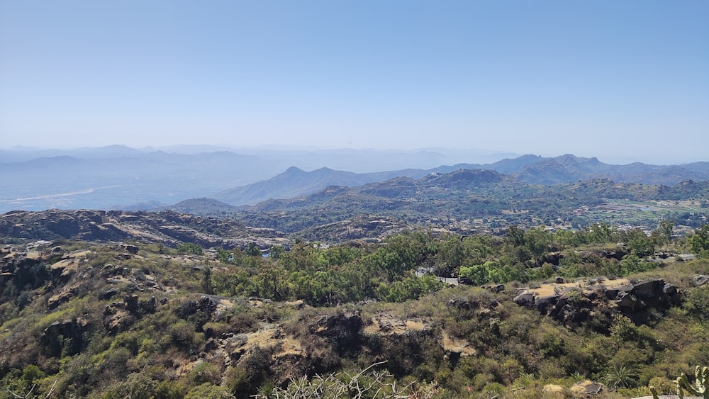 a view of a mountain range with trees and mountains in the background