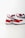 Two athletic shoes with bold red, white, and dark blue color blocking. The shoes feature a sleek, modern design with a flat sole and a recognizable logo in black on the heel. The upper part is made of a mix of textiles with some parts having perforations for breathability.