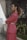 a woman in a pink suit standing in front of a building