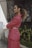 a woman in a pink suit standing in front of a building