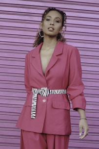 a woman in a pink suit and zebra print belt