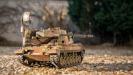 A military tank model painted in camouflage, set against a neutral background.