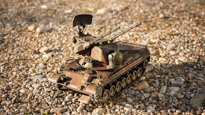 Top view of a minimalist, black 3D printed military vehicle model on a textured dark background.