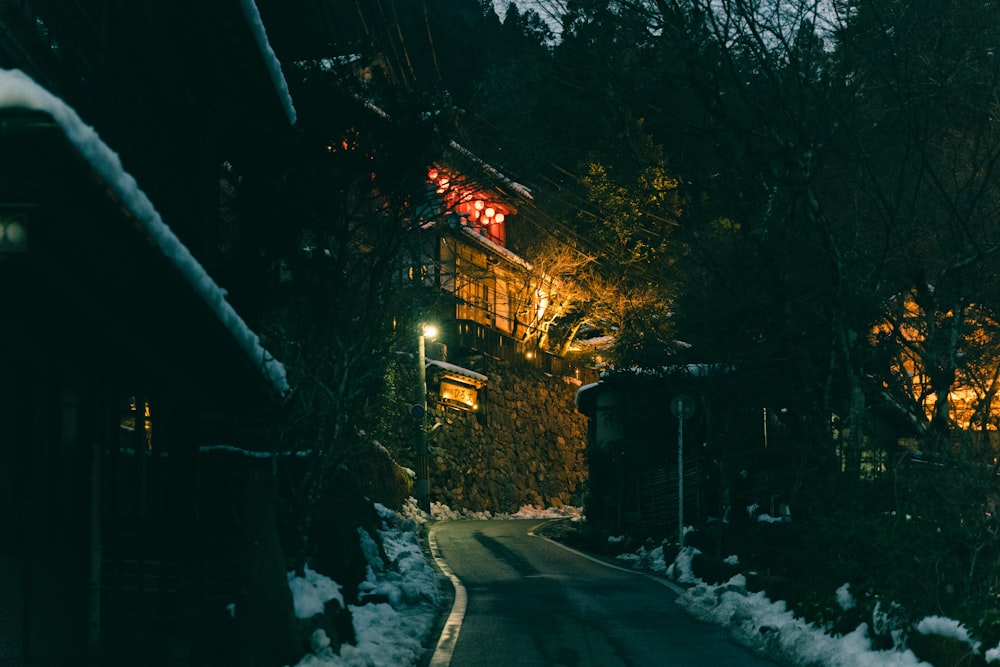 Eine Straße mit Schnee auf dem Boden in der Nacht