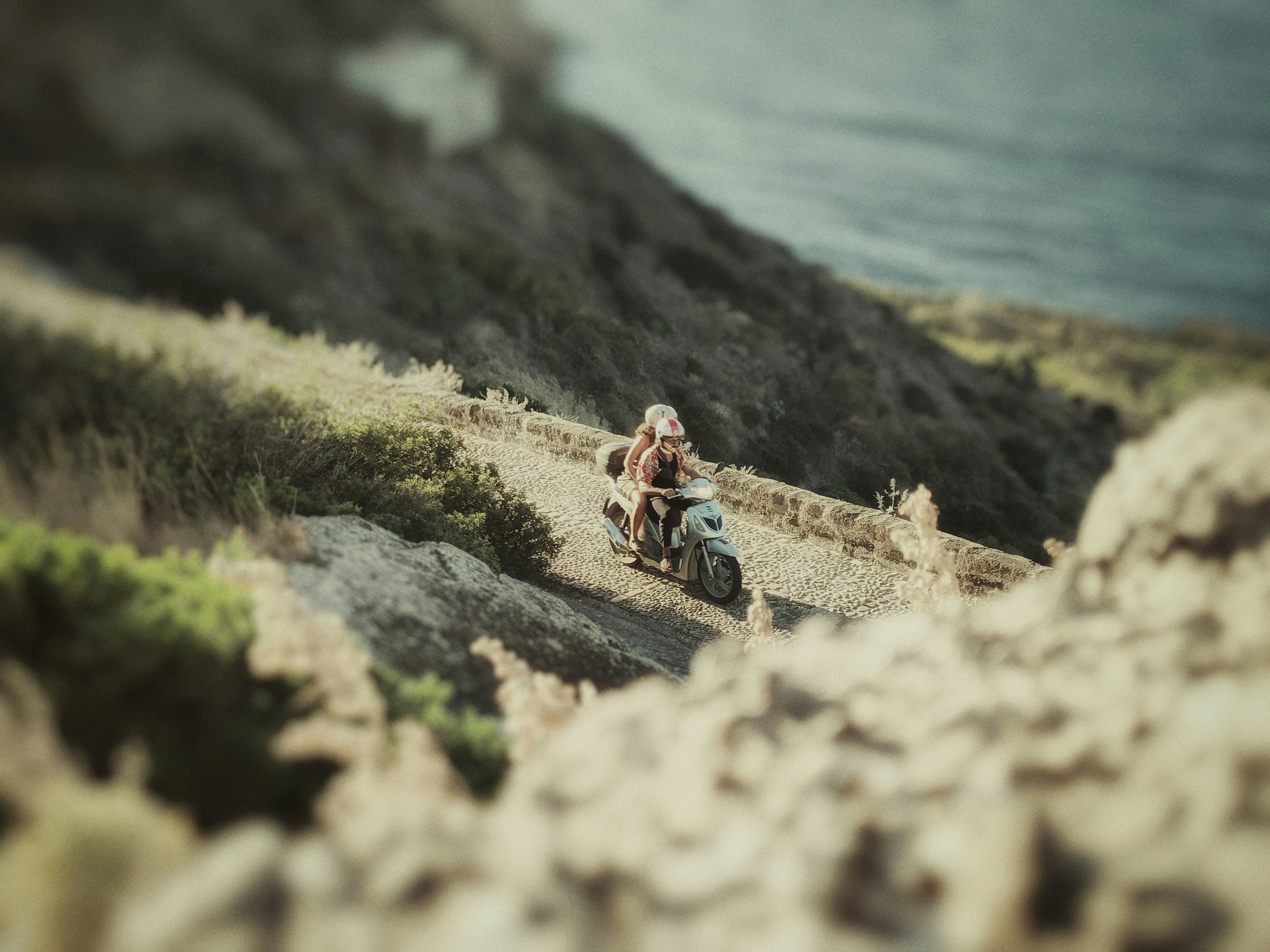 a man riding a motorcycle down a dirt road