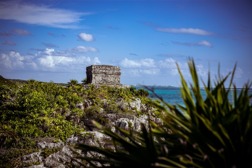 a small tower on a rocky cliff near the ocean