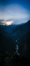A serene Andean mountain landscape at sunset with warm earthy tones and a flowing river