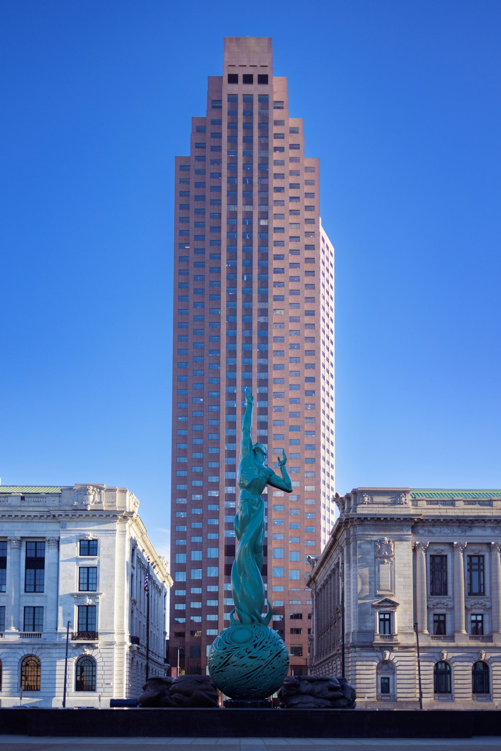 uma estátua de um cavalo na frente de um edifício alto