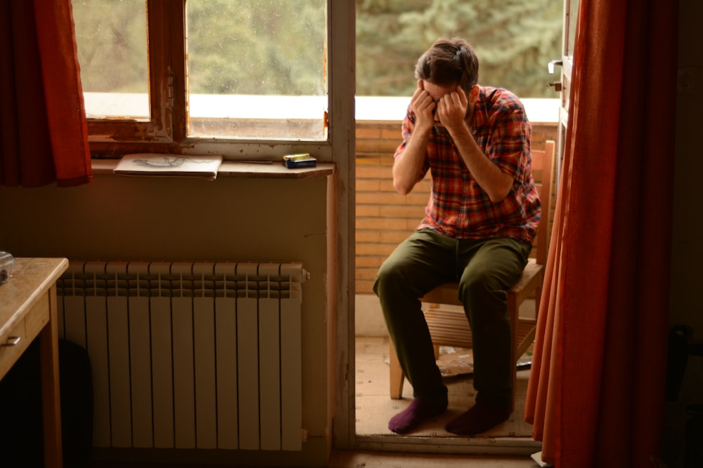 a person sitting on a chair looking out a window