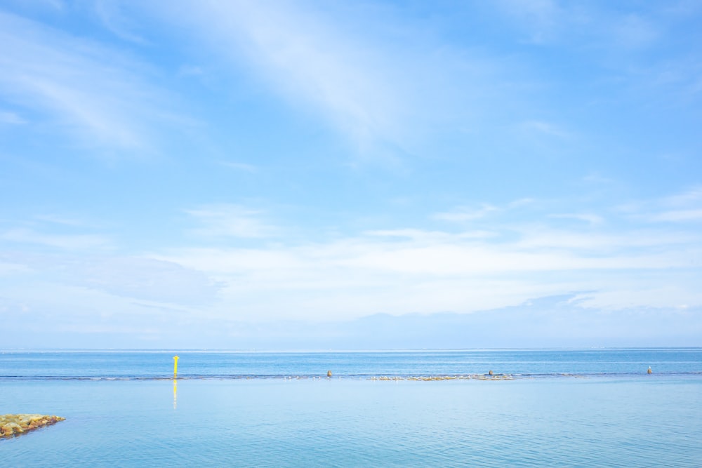 a large body of water sitting under a blue sky