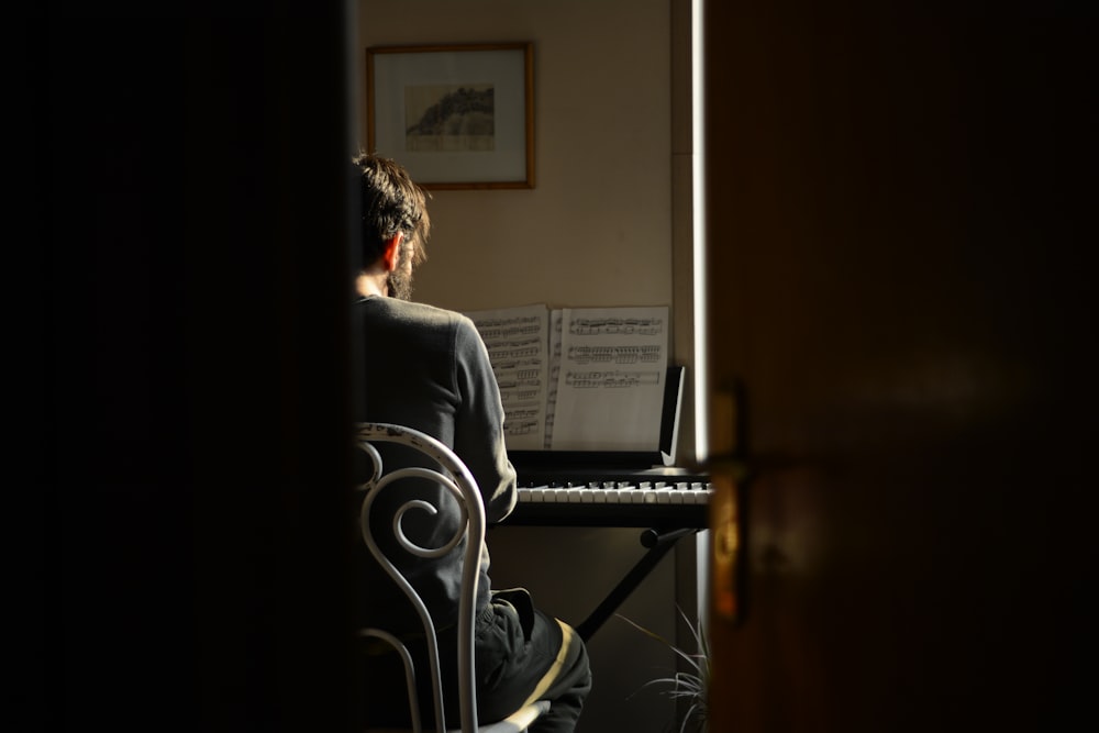 a woman sitting at a piano in a dark room