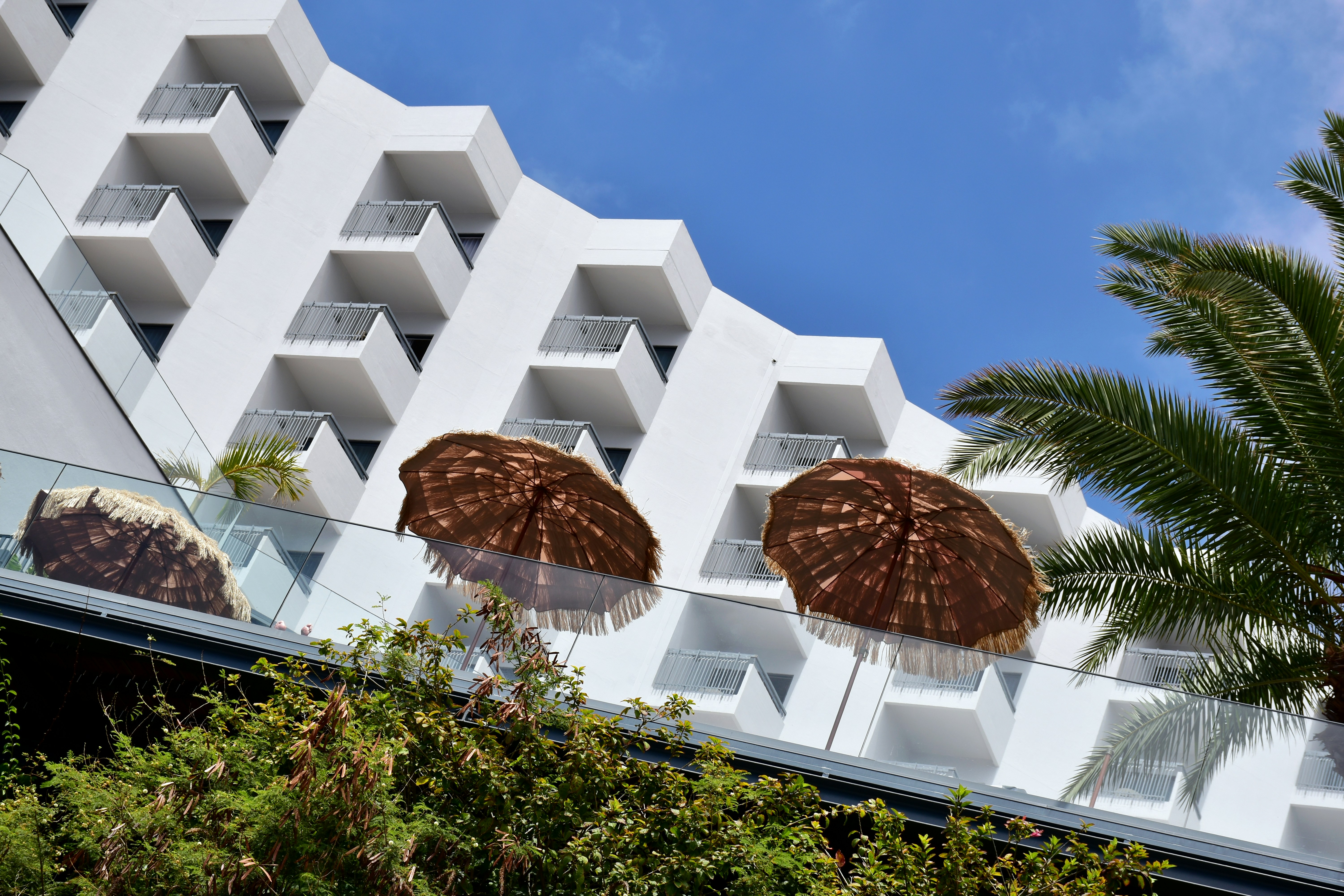 two brown umbrellas sitting in front of a white building