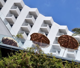 two brown umbrellas sitting in front of a white building