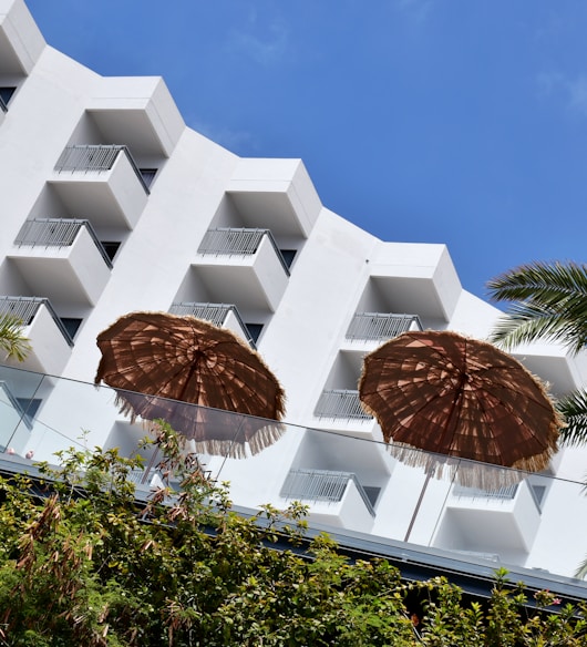 two brown umbrellas sitting in front of a white building