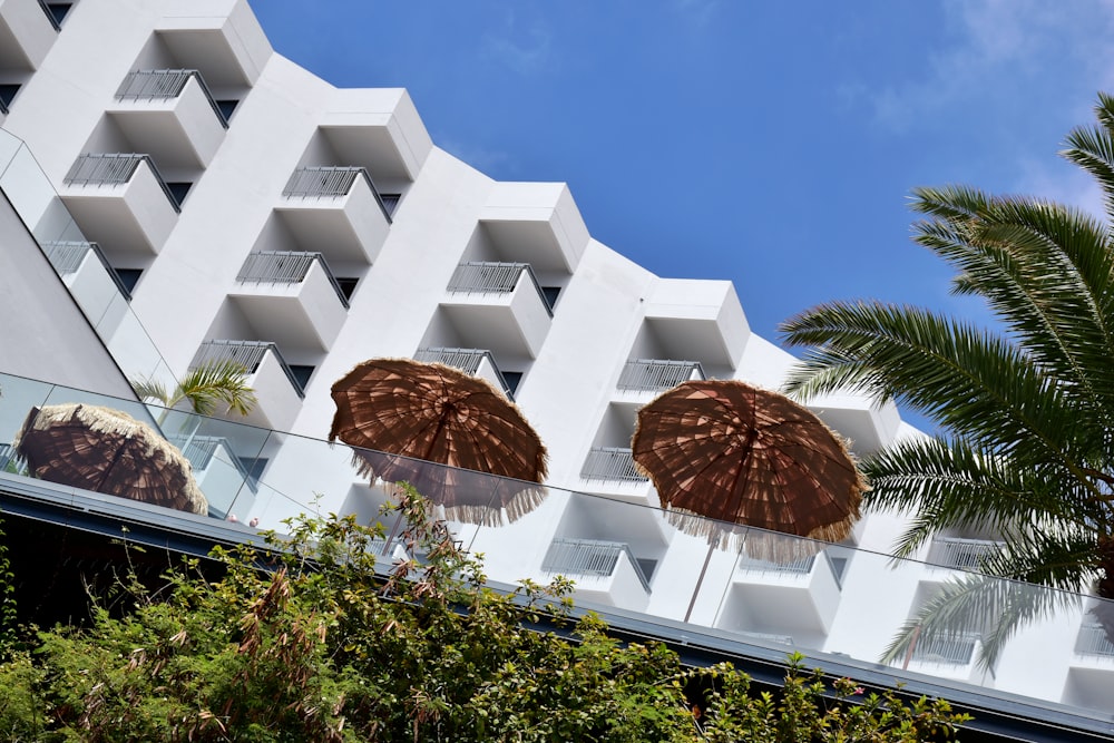 two brown umbrellas sitting in front of a white building