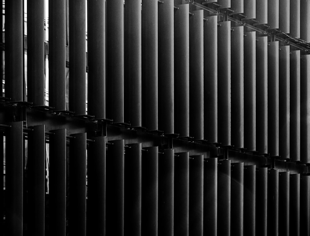 a black and white photo of a wall made of metal pipes