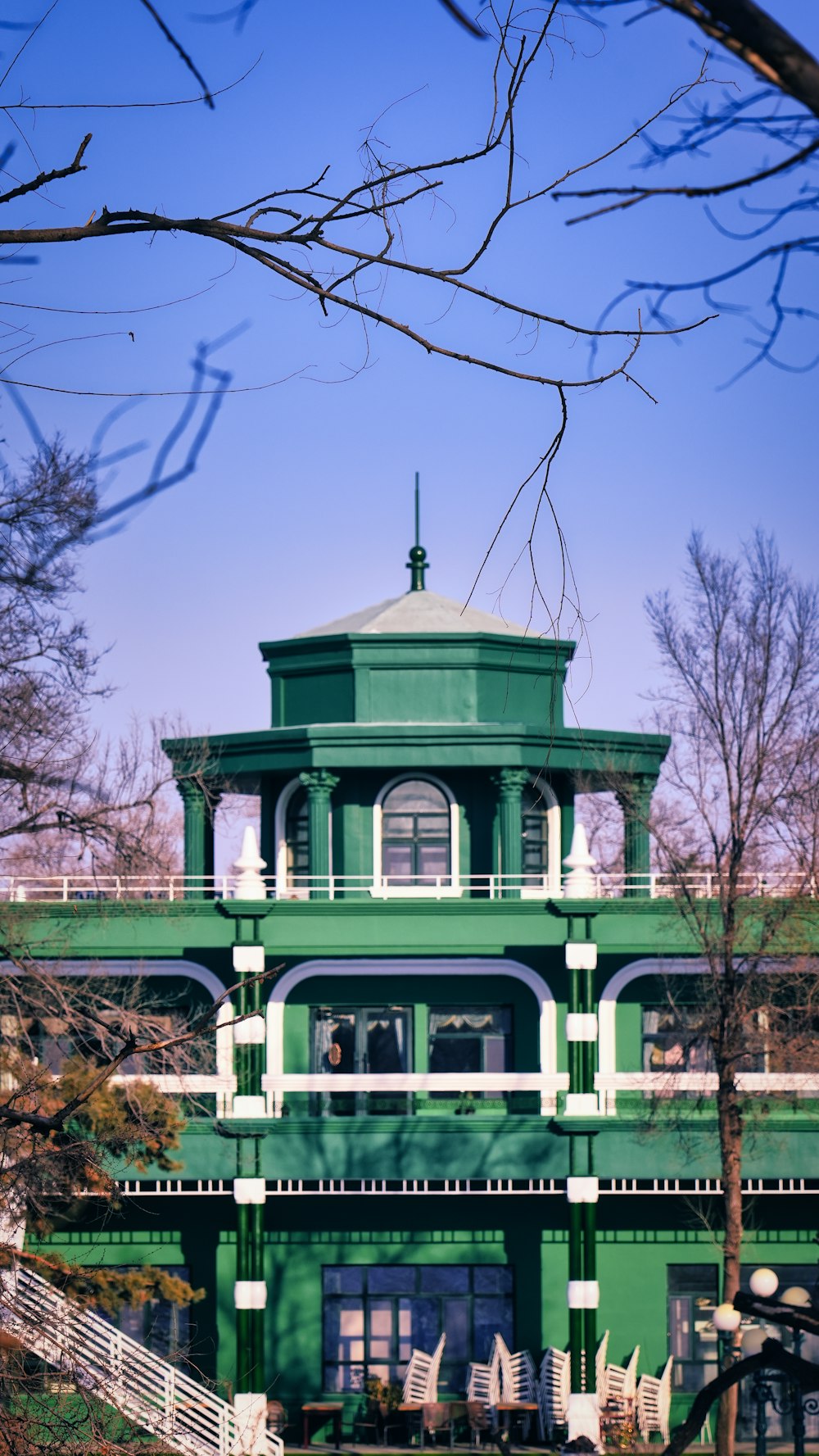 a green building with a clock on the top of it