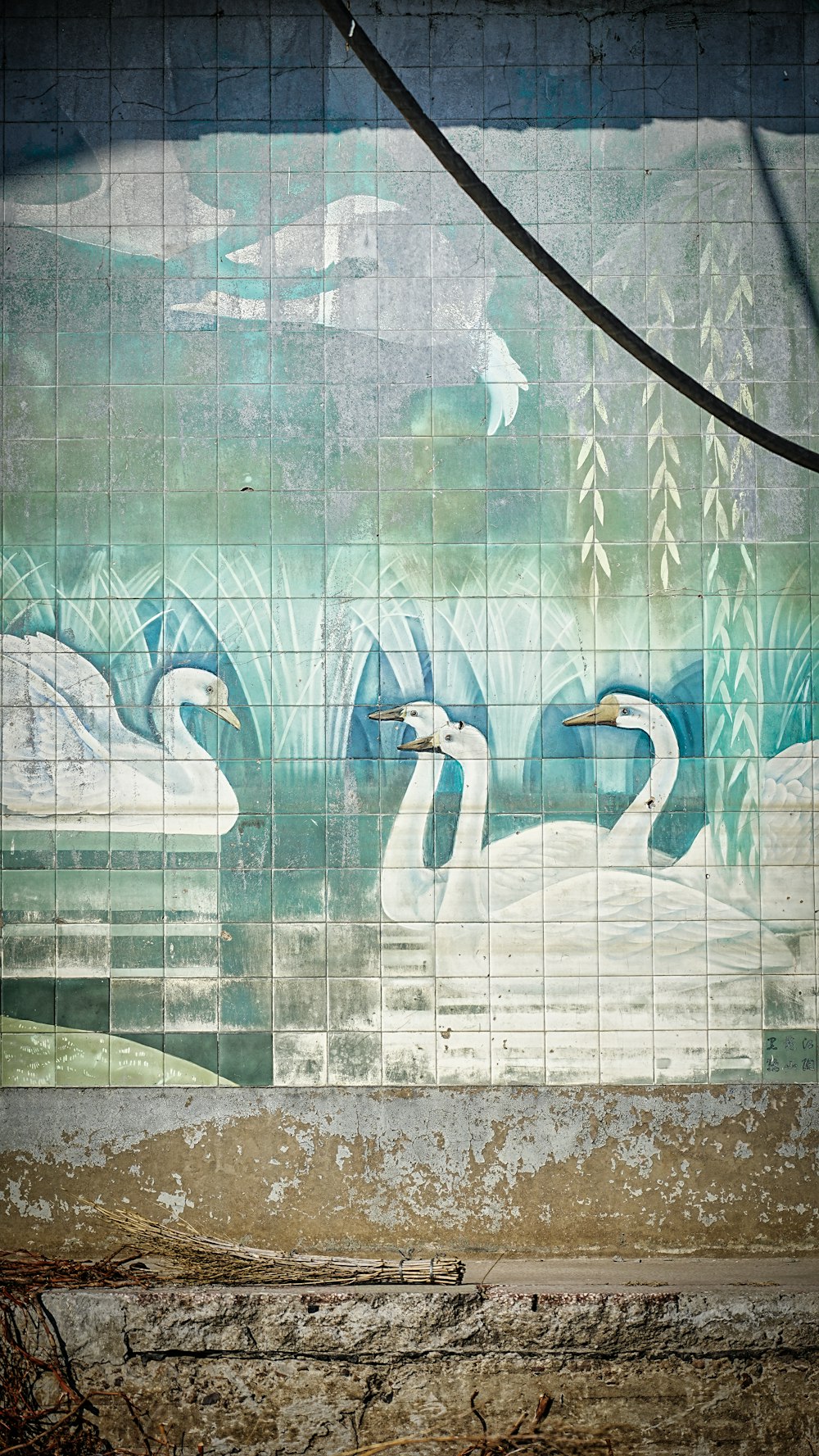 a painting of swans on a tiled wall