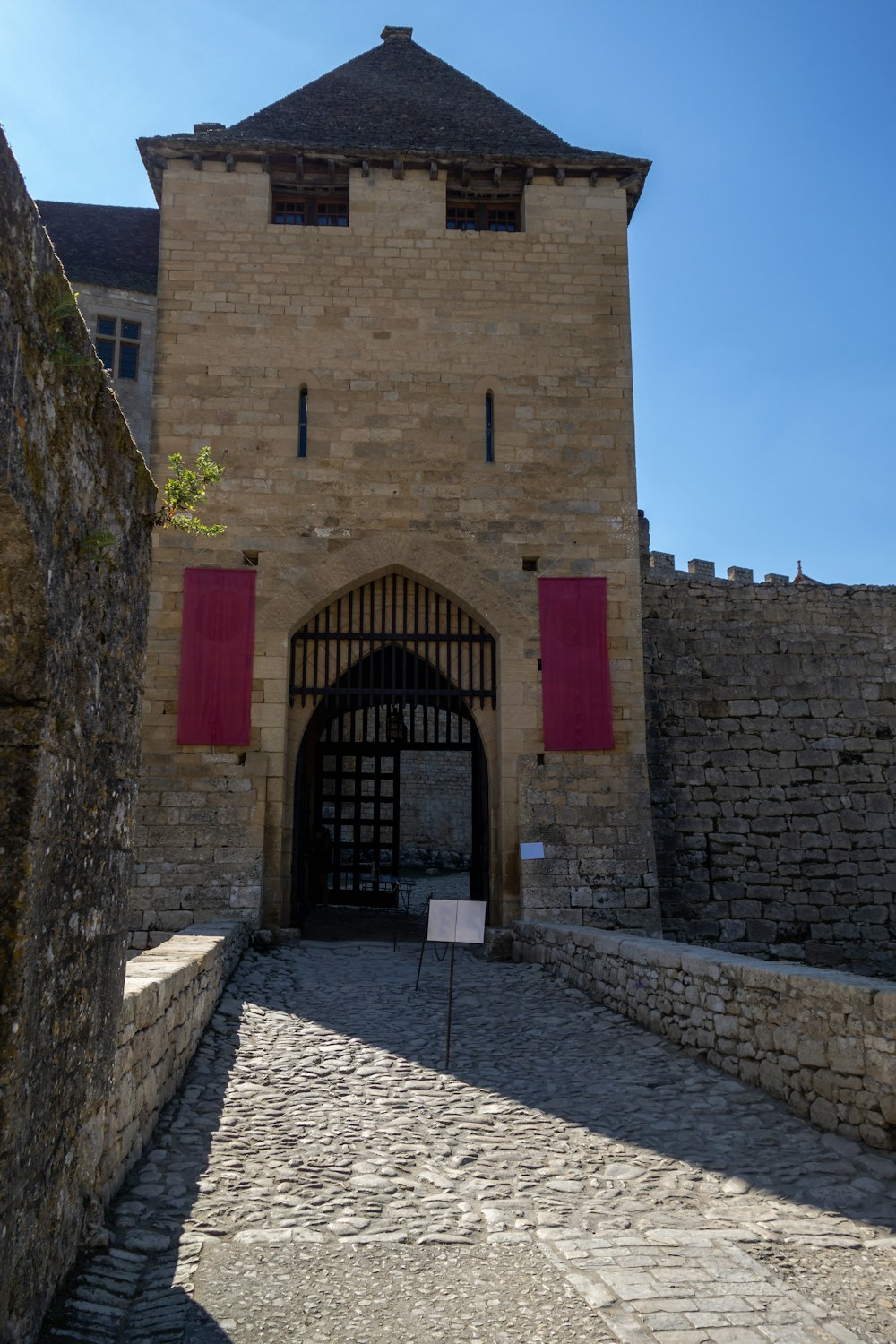 a stone building with a red door and red shutters