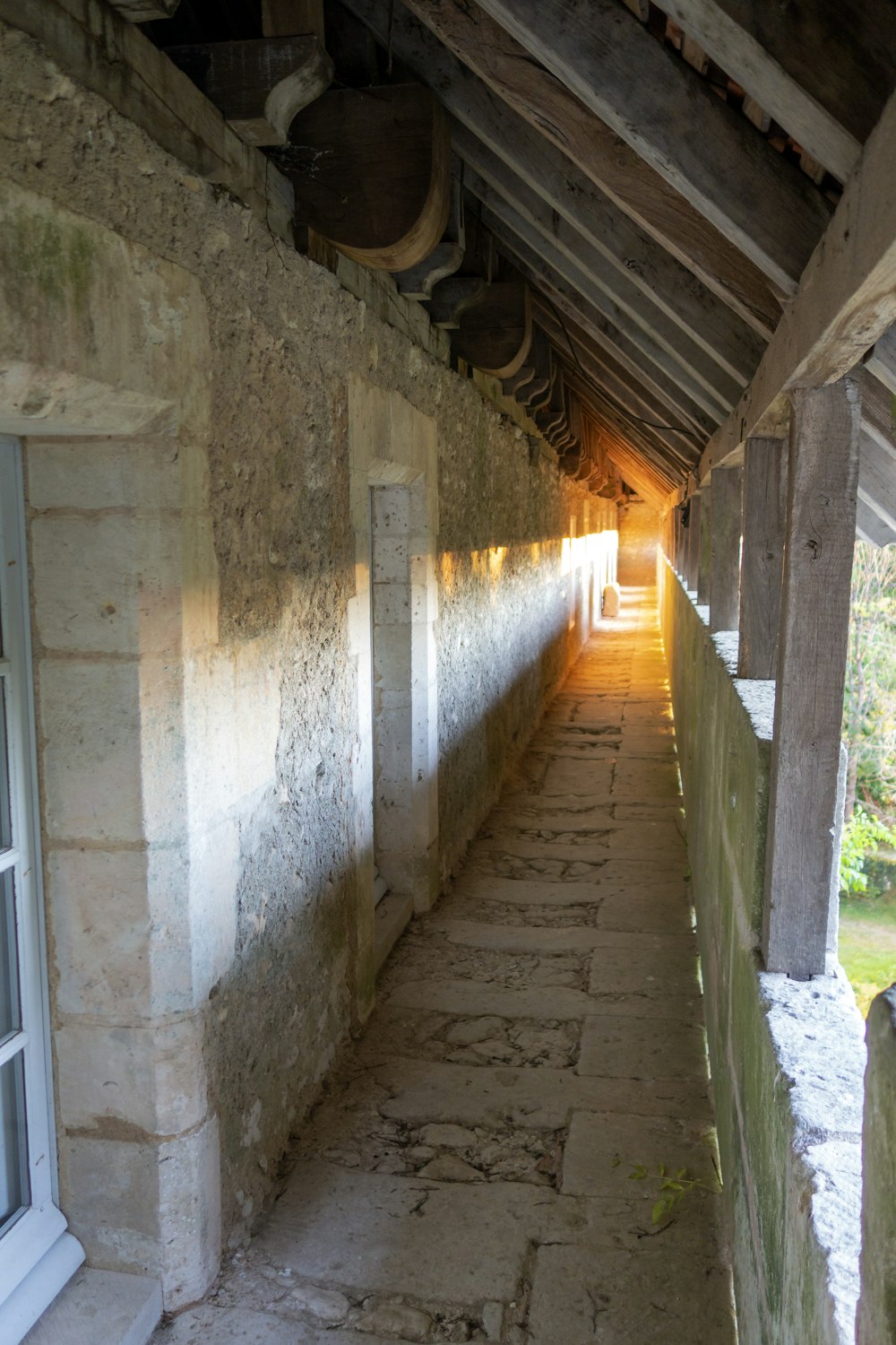 a long narrow hallway with pots hanging from the ceiling