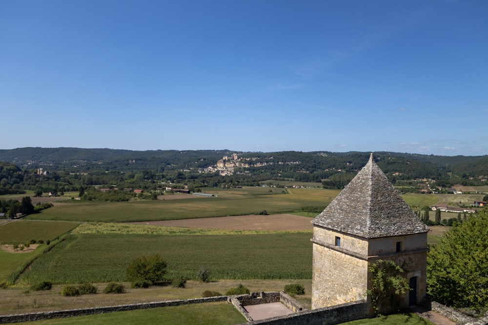 an old building with a tower in the middle of a field