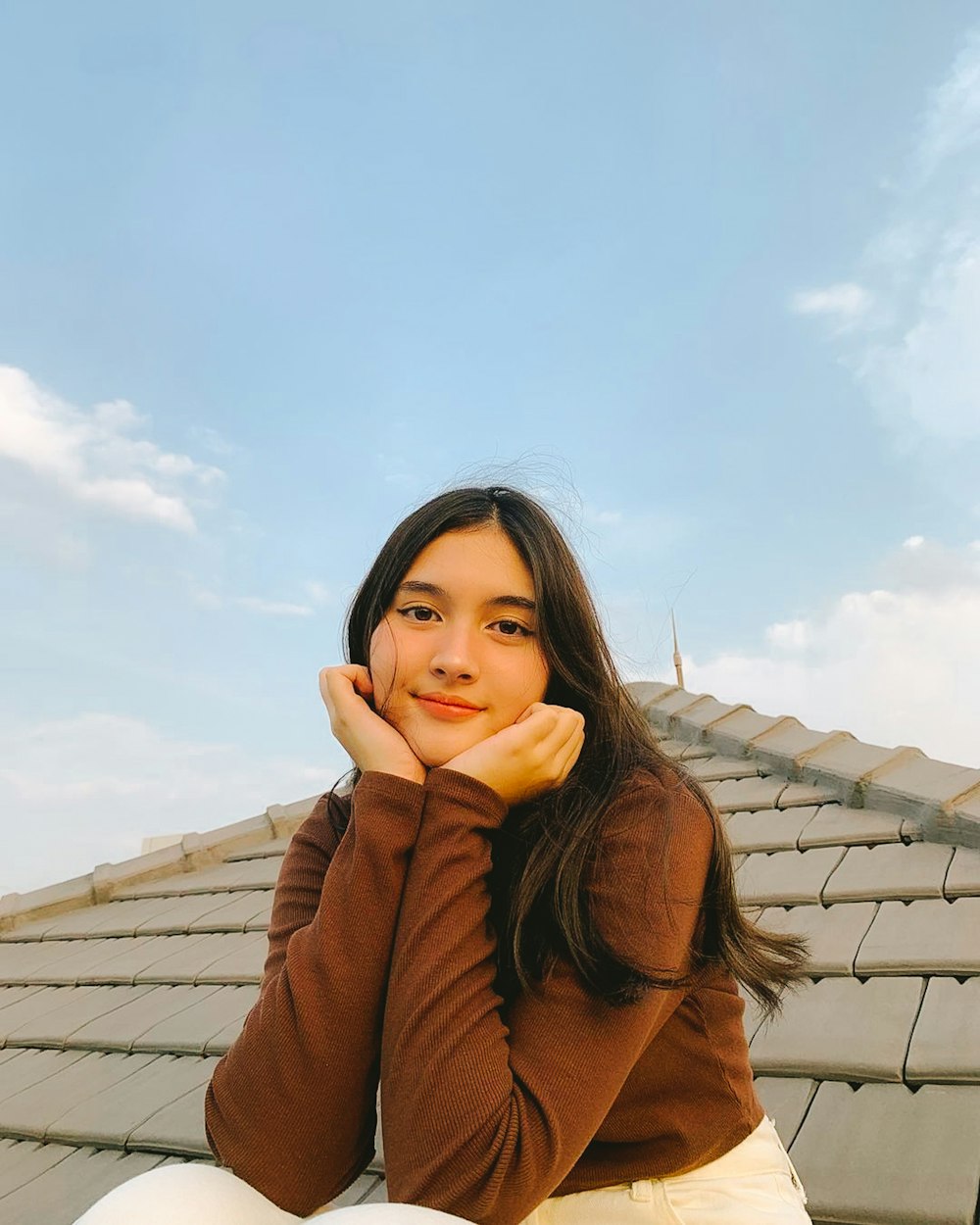 a woman sitting on the roof of a building