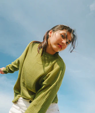Close-up of a model wearing a soft, earth-toned reverd sweater outdoors.