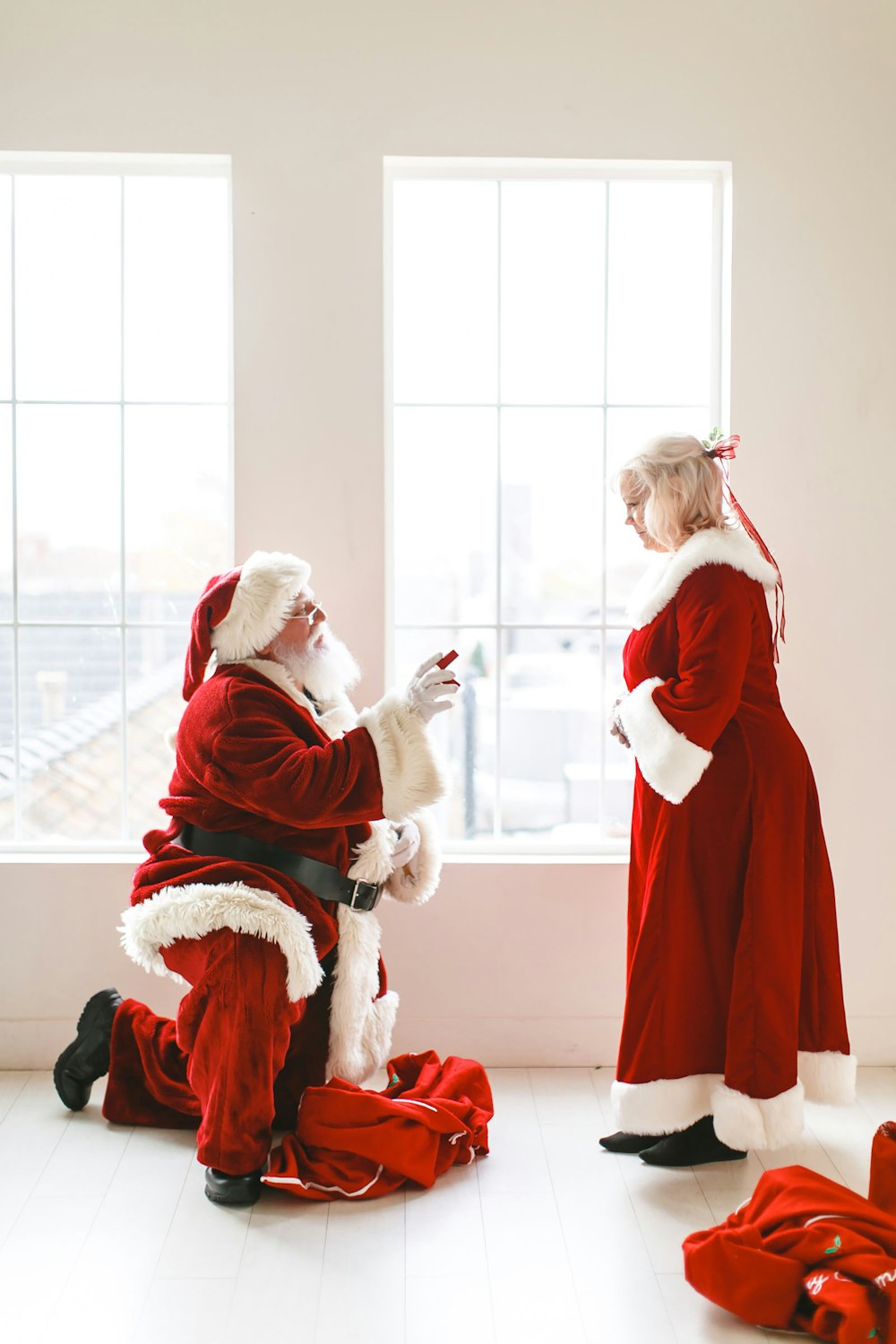 a little girl dressed as santa claus and a man dressed as santa claus