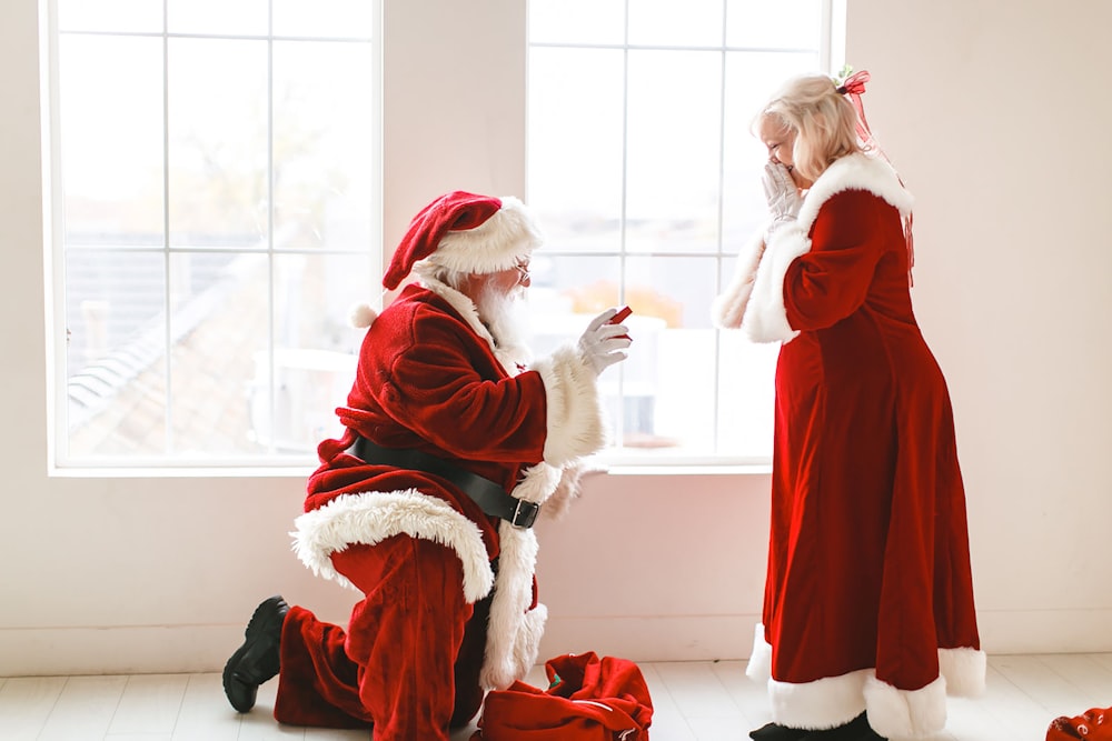 a man dressed as santa claus and a woman dressed as santa claus