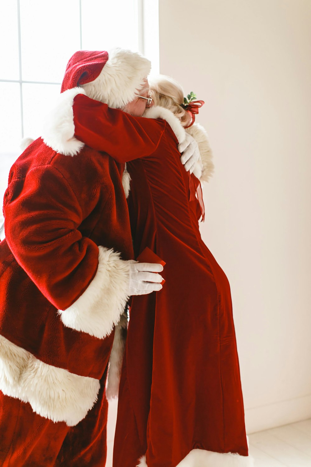 a man in a santa suit hugging a woman