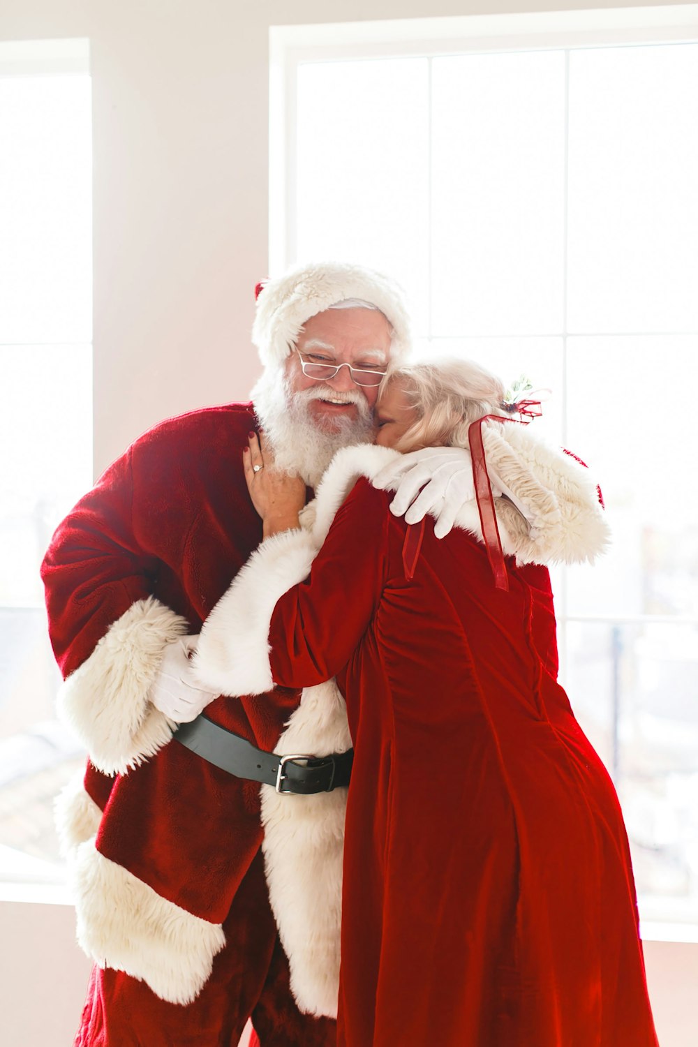 a man in a santa suit hugging a woman