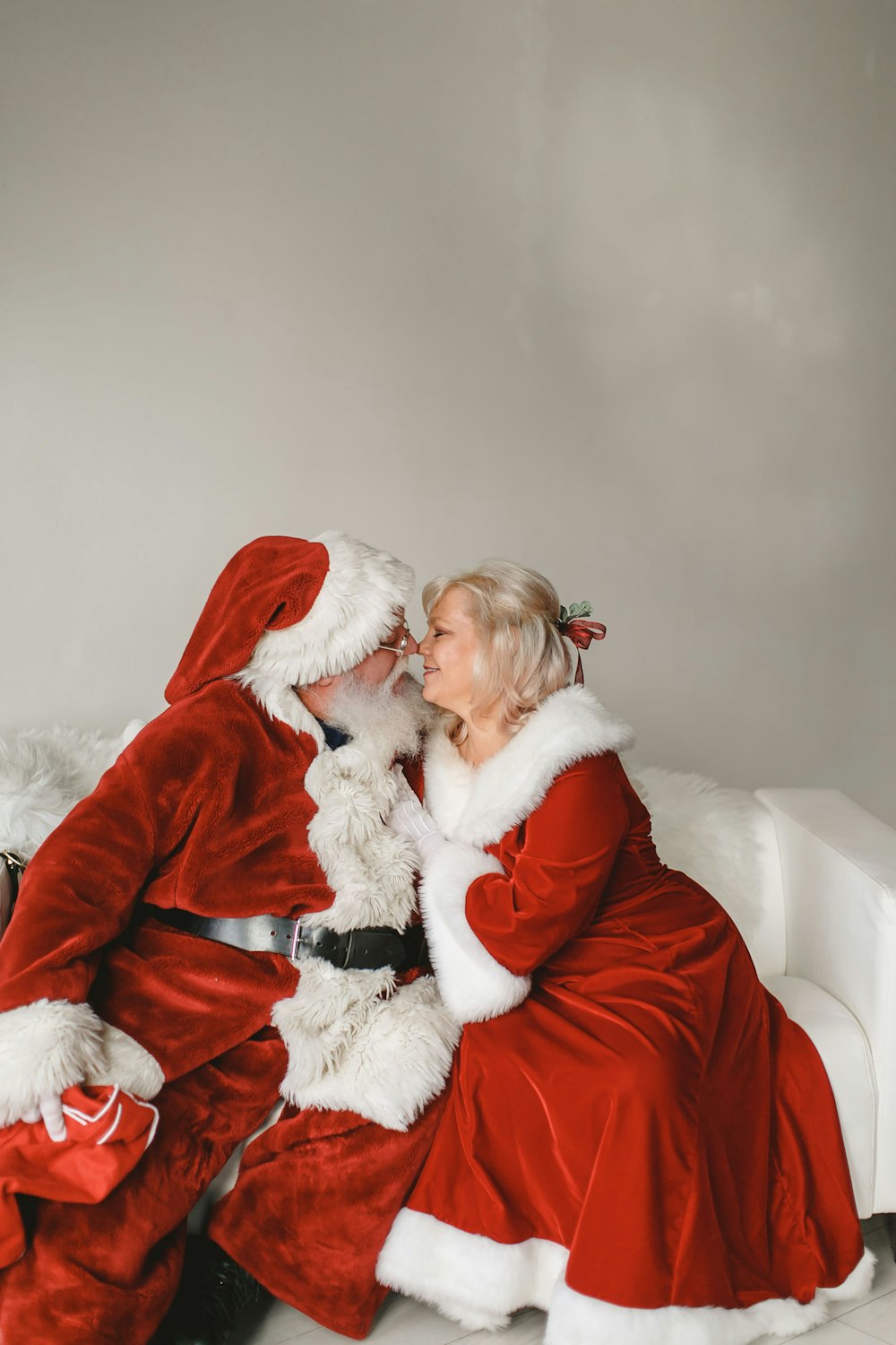a man dressed as santa claus kissing a woman