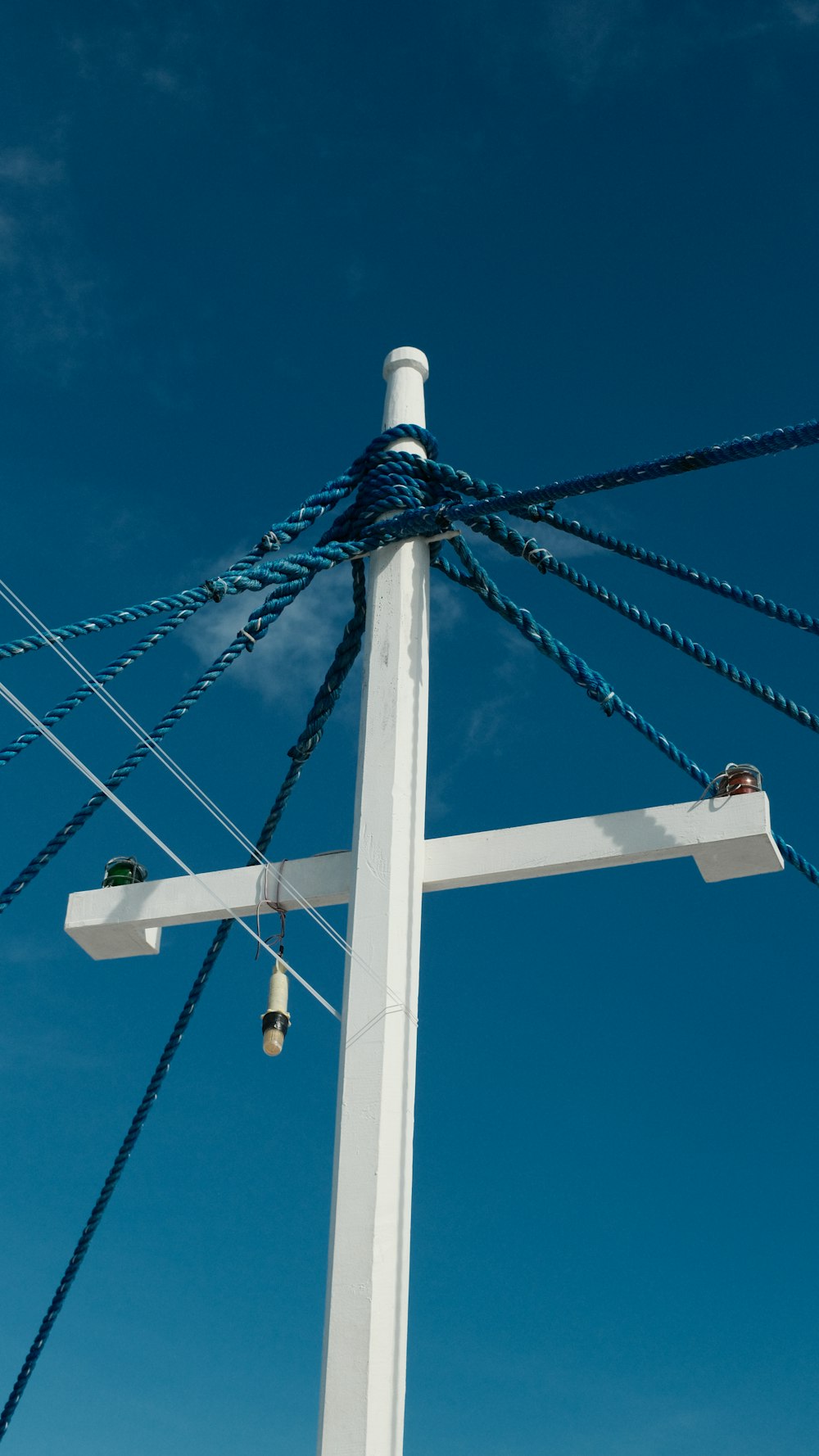 a white cross on a pole with blue sky in the background