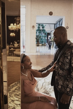 Elegant older couple warmly greeting a concierge in a stylish Naples home.