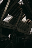 A sturdy wooden roof frame treated and restored inside a rustic attic.
