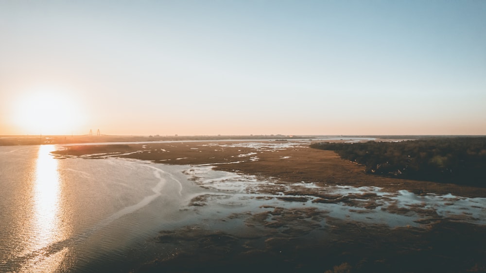 the sun is setting over a body of water