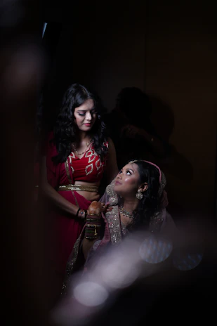 a woman standing next to a woman in a red dress