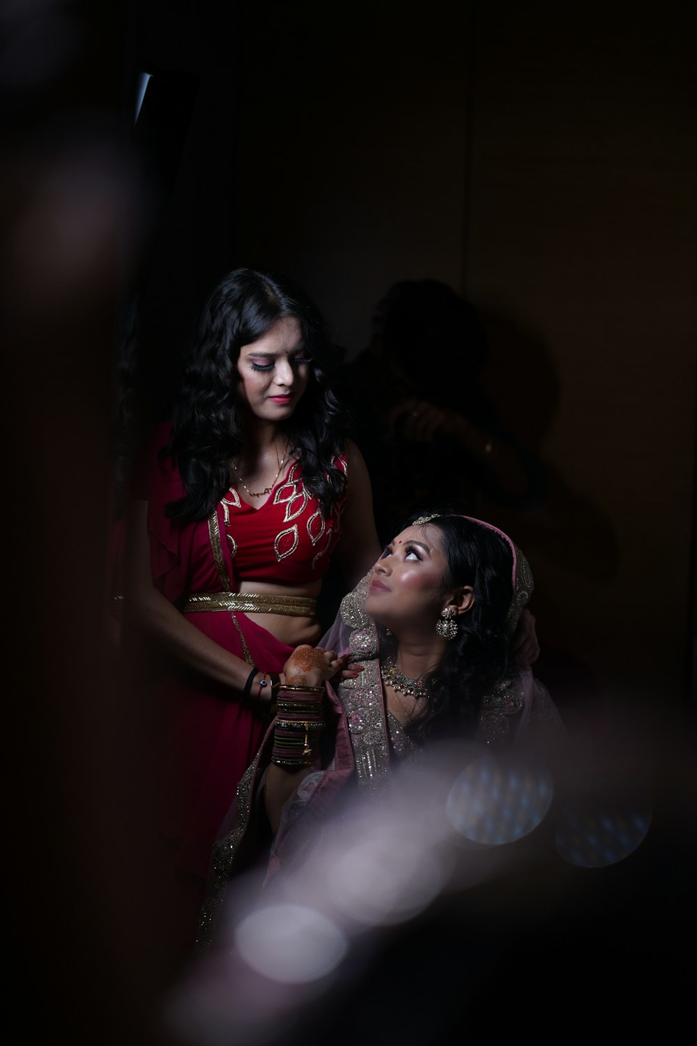 a woman standing next to a woman in a red dress