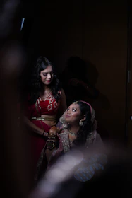 a woman in a red dress standing next to a woman in a red dress