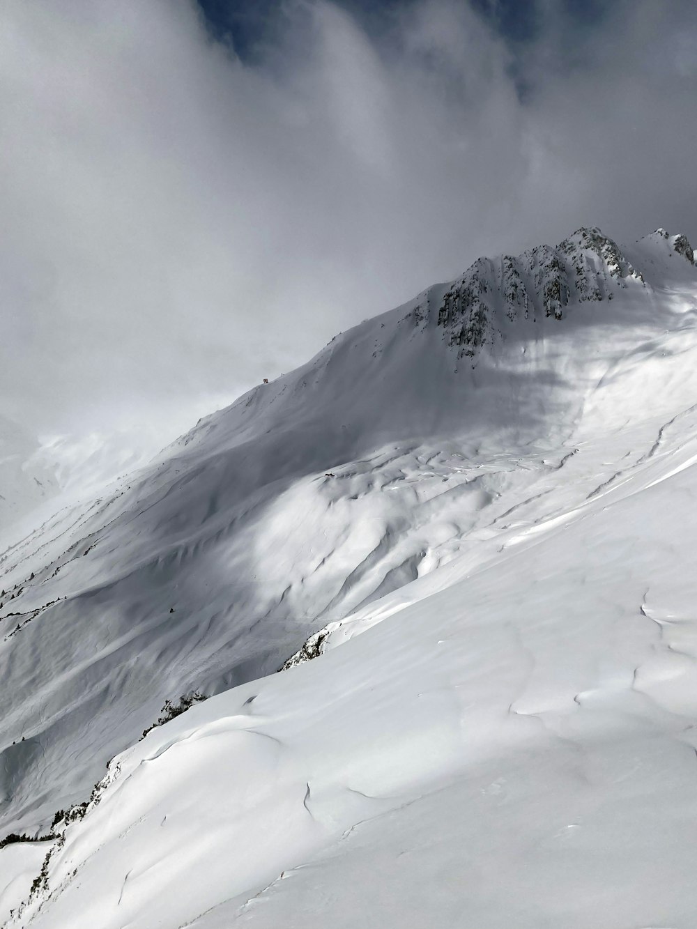 a man riding skis down the side of a snow covered slope