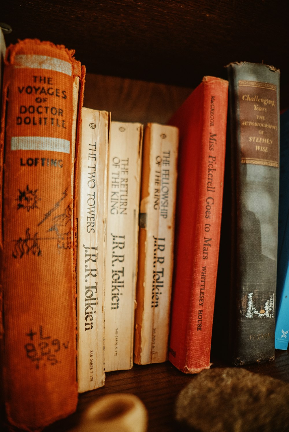 a row of books sitting on top of a wooden shelf