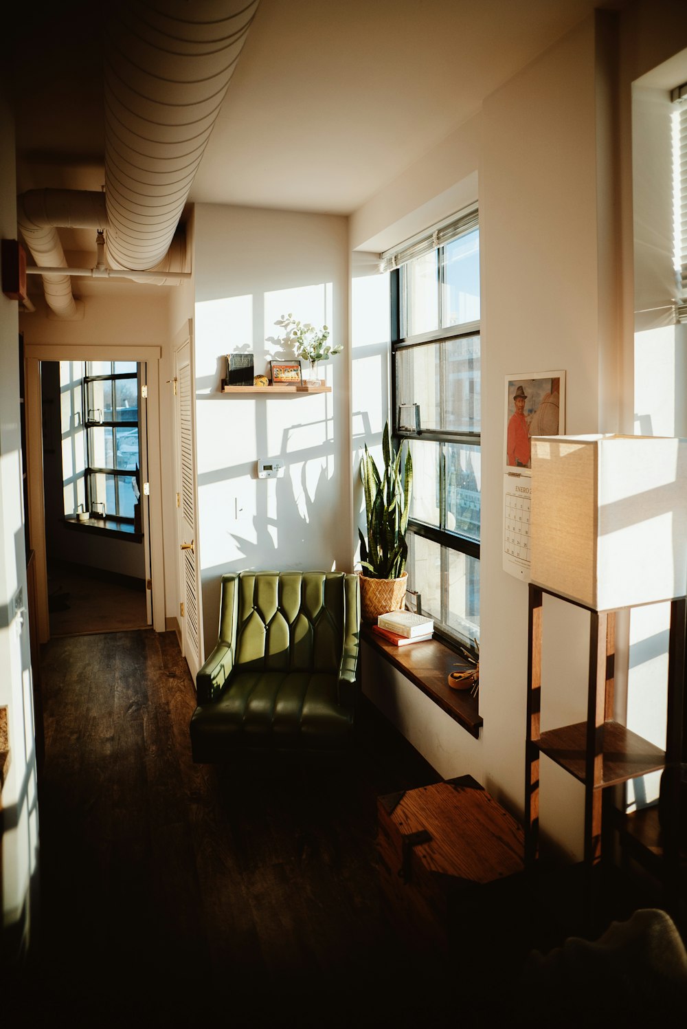 a living room with a green couch and a window