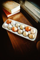 A wooden crate filled with fresh farm eggs, nestled in straw with morning light streaming in.