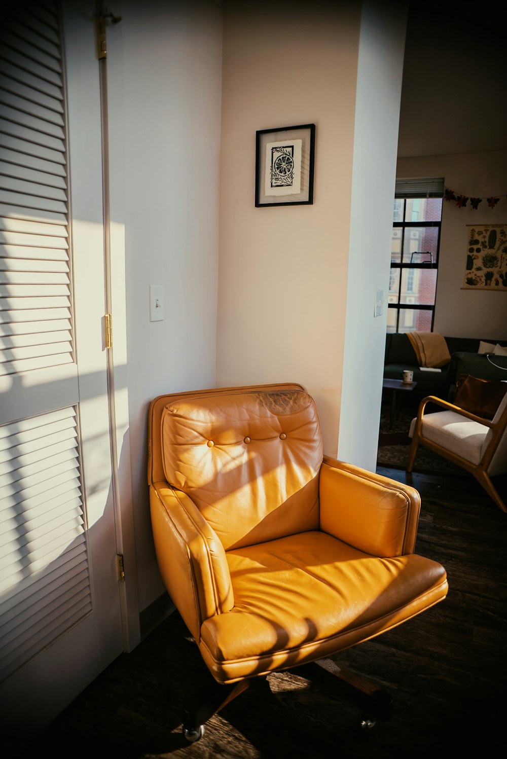 a brown leather chair sitting next to a white wall