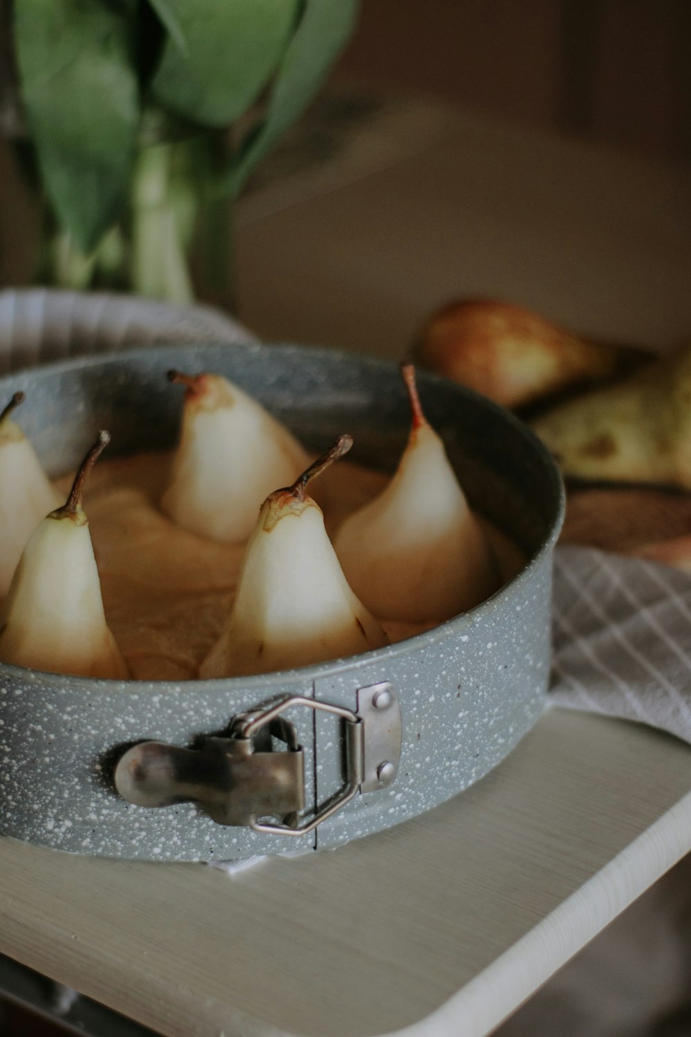 a metal pan filled with pears on top of a table