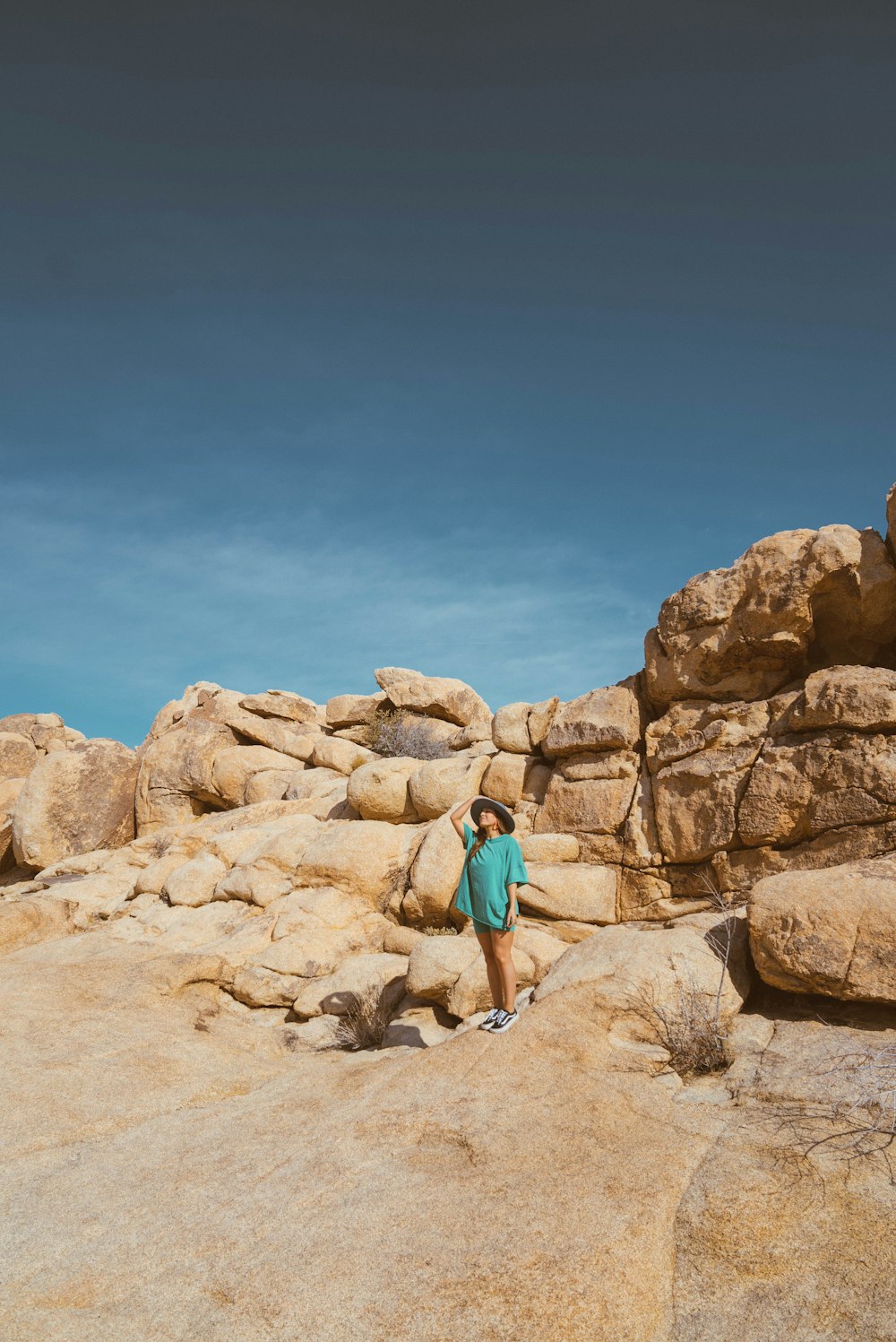 a woman standing on top of a large rock formation